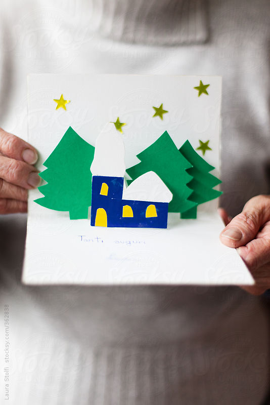 Woman showing a Christmas card crafted by a child with greetings written in childhood calligraphy by Laura Stolfi