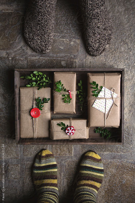 Feet with warm winter socks standing in front of Christmas gifts by Pavel Gramatikov