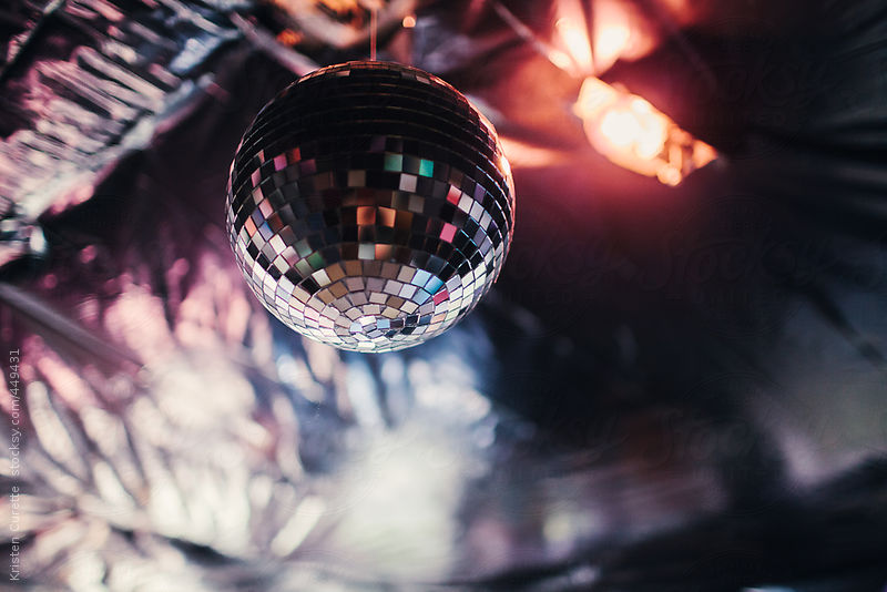 Disco ball hanging from the ceiling of a house party by Kristen Curette