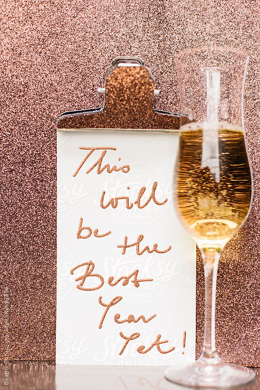 New year message with a glass of champagne in front of a glitter background by Beatrix Boros