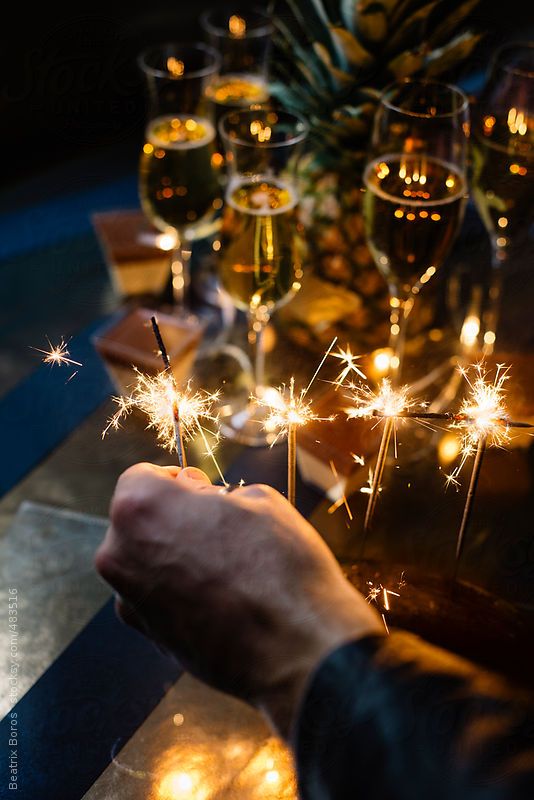 Man's hand sets on fire some sparkles for celebration by Beatrix Boros
