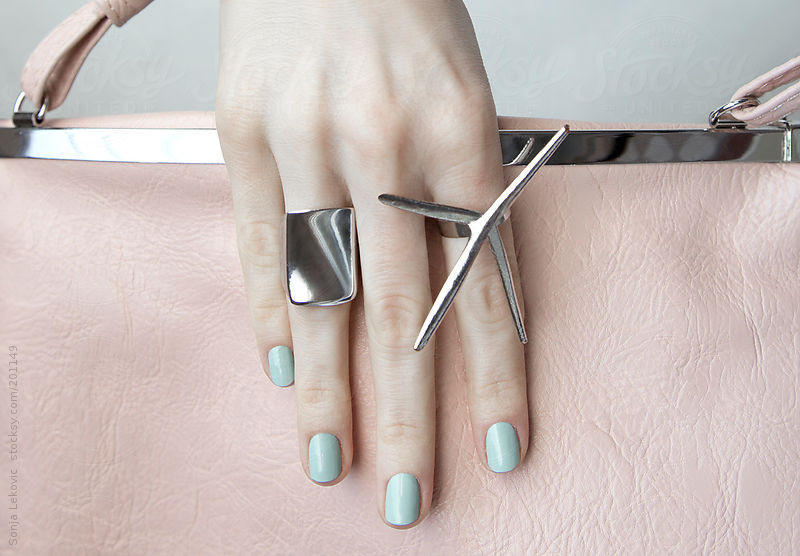 silver rings on hand holding a pink purse by Sonja Lekovic