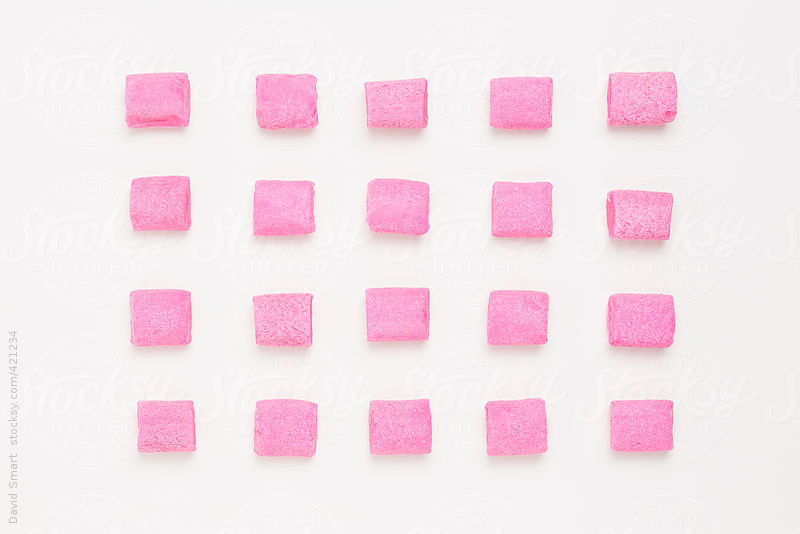 Rows of pink bubble gum on white background by David Smart