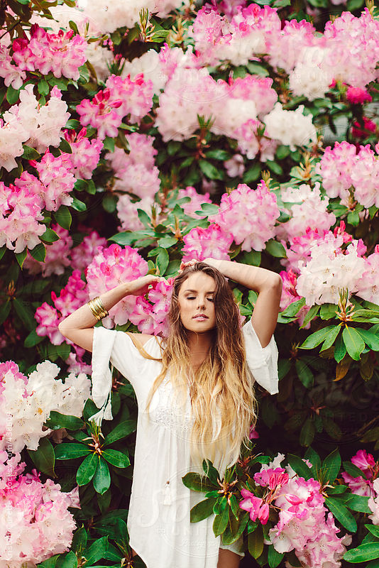 Pretty woman in posing in pink flowers by Kristen Curette