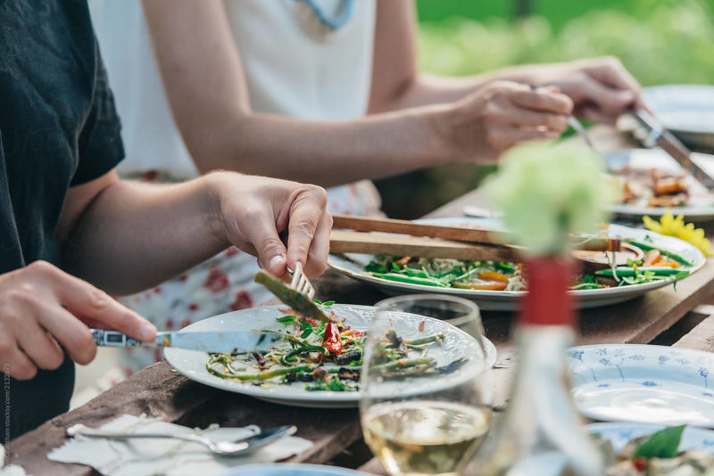 Close Up Of Hands And Plates During A Dinner Party